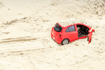 red toy car stuck in sand