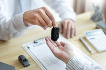 Insurance concept the customer receiving the car key after finishing the contract of car purchasing