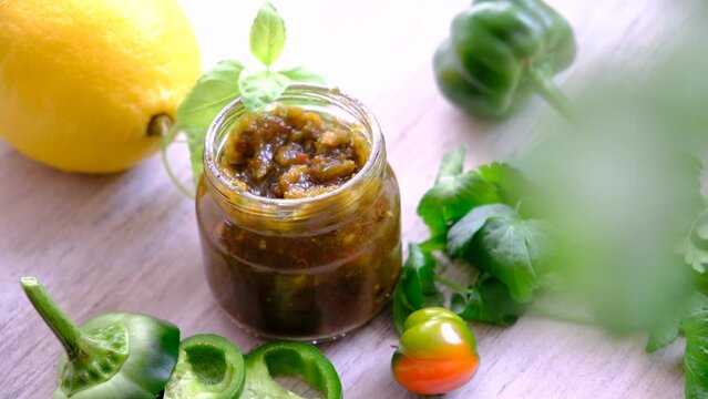Jalapeno chili pepper pickled pepper slices preserved in glass jar. Opened of chunky spicy salsa sauce