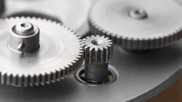 Gears rotating in a mechanical device. Machine metal gears rotating abstract. Cog wheels machinery, close up, macro
