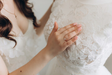 Morning of the bride. Bride's fees. The bride admires and touches her dress
