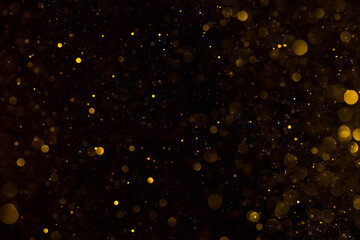 Abstract shiny golden glitter particles bokeh lights defocused background