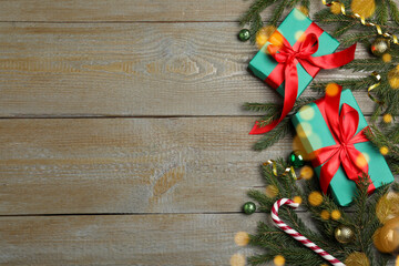 Christmas greeting card with space for text. Flat lay composition of fir tree branches and festive decor on wooden background