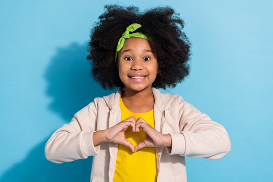 Portrait of attractive trendy funny cheerful girl schoolkid showing heart shape isolated over bright blue color background