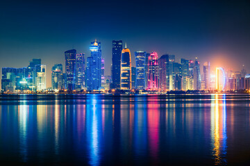 Night view on the centre of the city Doha, Qatar and the Gulf. Many modern luxury building and skyscrapers illuminated with numerous lights.