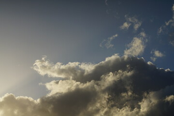 Fototapeta na wymiar Stimmungsvoller Himmel mit unterschiedlichen blauen Wolken und Sonnenlicht