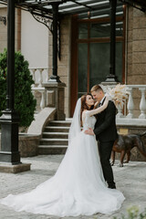 elegant wedding couple gently hugging in sunlight in old courtyard in european street. luxury bride and groom embracing. romantic sensual moment