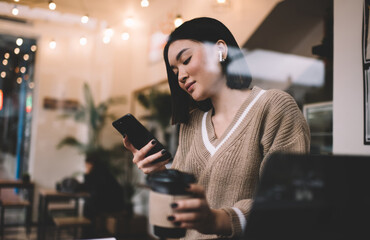 Young millennial asian girl working in cafe