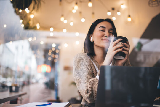 Young millennial asian girl working in cafe