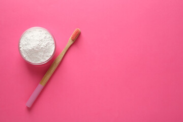 Fototapeta na wymiar Bowl of tooth powder and brush on pink background, flat lay. Space for text