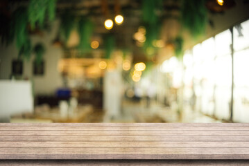 Empty wooden table top with lights bokeh on blur restaurant background.