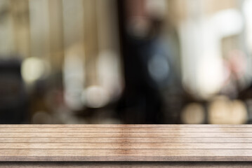 Empty wooden table top with lights bokeh on blur restaurant background.