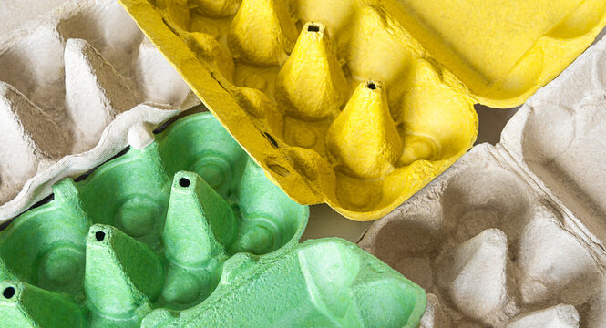 Top view of empty egg cartons. green, grey and yellow egg trays