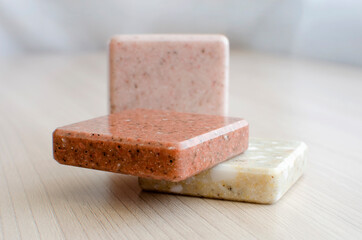 selection of stone samples for countertops and floors. Pieces of artificial acrylic stone in a sample box. A set of shades of countertops of different textures