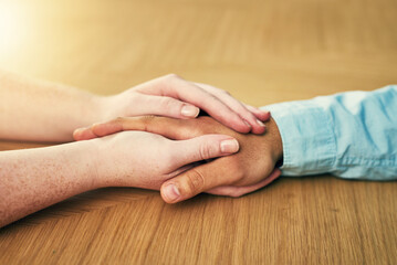 Help - sometimes we need it, sometimes we give. Cropped shot of a man and woman holding hands in comfort on a table.