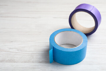 Two different rolls of adhesive tape on wooden table. Space for text