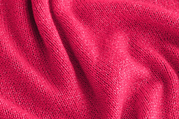 Fototapeta na wymiar Soft knitted pink sweater texture closeup. Light orange abstract background. Trendy soft magenta red backdrop for web design. Luxury twisted fabric backplate 