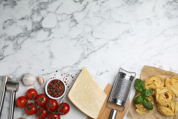 Flat lay composition with cooking utensils and fresh ingredients on white marble table. Space for...