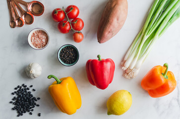 Overhead flat lay of dinner meal prep with fresh healthy vegetables on a white background