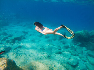 beautiful woman swimming underwater with snorkeling mask and flippers