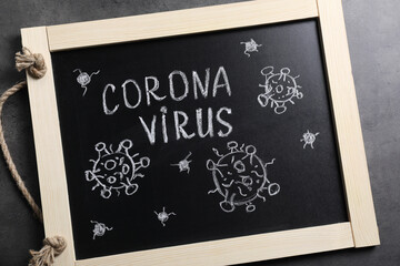Blackboard with word Coronavirus on grey table, top view