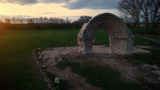 Aerial view of the ruined medieval arch of San Miguel de Mazarreros at dusk, in Olmillos de Sasamon. Burgos, Spain. High quality 4k footage