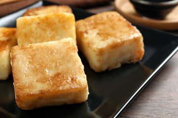 Delicious turnip cake on ceramic black plate, closeup