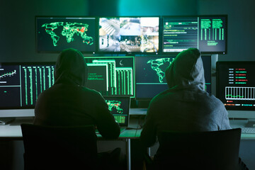 Control room monitoring surveillance video camera control city - Two Hooded hackers in dark room...