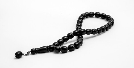 Black prayer beads on a white background