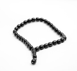 Black prayer beads on a white background