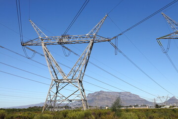 Electric pylons carrying high tension electric cables, near Cape Town in the Western Cape, South Africa. - obrazy, fototapety, plakaty