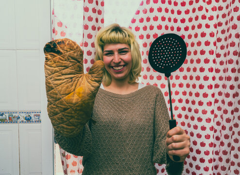Mujer joven feliz aprendiendo a cocinar,  ama de casa se rie porque quem&oacute; la comida, concepto de estilo de vida