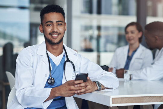 My favourite person just texted me. Shot of a young male doctor using his smartphone while taking a break.