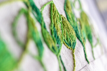 detalle de textura de bordado con hilo de algodón en colores verdes, close up con desenfoque