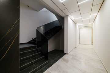 bright interior of the corridor with light and black stairs