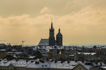 Aerial panorama of Old Krakow at dawn with St. Mary's Basilica on the medieval main market square of the city, snow on the roofs of Krakow houses in cloudy weather, Poland
