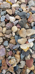 A scattering of stones lying on the ground in daylight. Mobile photography. Background for design, decor and texture.