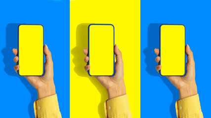 A woman's hand holds a blue smartphone with a blank screen and a modern design in a blue and yellow background