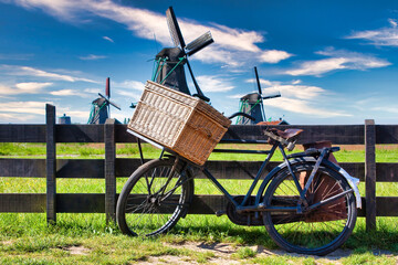 Bicycle with windmill and blue sky background. Scenic countryside landscape close to Amsterdam in...