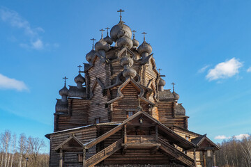 wooden church made according to ancient drawings of the Intercession Cathedral against the blue sky in winter