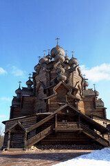 wooden church made according to ancient drawings of the Intercession Cathedral against the blue sky in winter