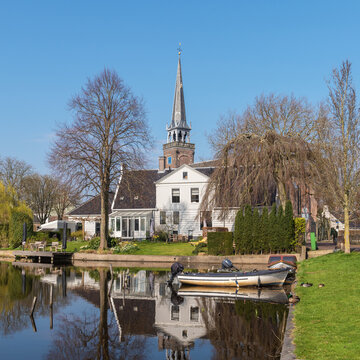  Scenic corner of a village with a lake and a church in the background, taken on a sunny spring day