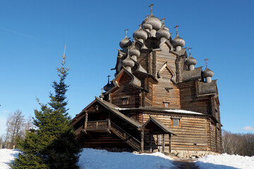 wooden church made according to ancient drawings of the Intercession Cathedral against the blue sky in winter