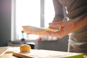 Woman hands preparing dough on a sunny day. Homemade bread, bakery while staying home.