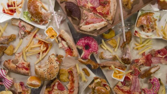 Irrational Attitude to Food. HD Loop. A wide variety of uneaten food items slowly rotate in front of the camera, symbolizing waste, irrationality and recycling