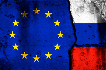 Europe Union and Russia crisis. Background with national flags on cracked wall photo