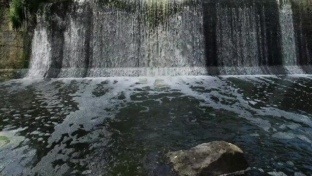 Artificial shaded waterfall on dam on Hirskyi Tikych river, Buky Canyon, Cherkasy Region, Ukraine.
