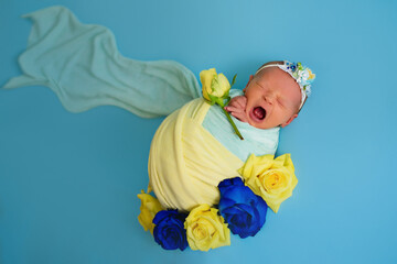 Ukrainian newborn crying in the studio patriotic blue yellow colors during the war in Ukraine 2022....
