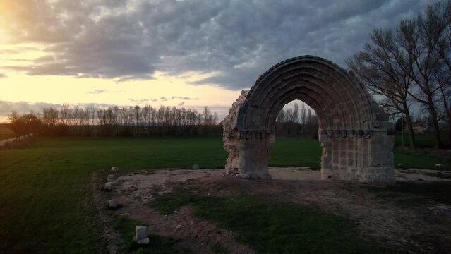 Aerial view of the ruined medieval arch of San Miguel de Mazarreros at dusk, in Olmillos de Sasamon. Burgos, Spain. High quality 4k footage