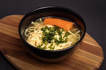 homemade broth sprinkled with parsley in an elegant black bowl o